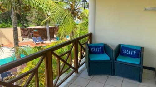 two chairs on a balcony with a view of a pool at Sonrisa Boutique Hotel - Adults Only in Kralendijk