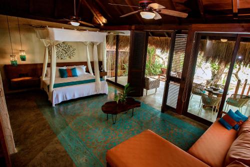 a bedroom with a bed and a couch in a room at Hotel Rancho Encantado in Bacalar