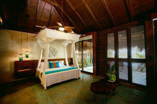 a bedroom with a bed with a canopy at Hotel Rancho Encantado in Bacalar