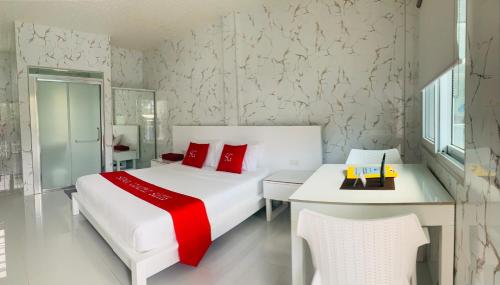 a bedroom with a large white bed and red pillows at Sena Gladyz Suites in Panabo