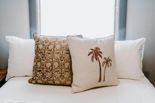 a group of pillows with palm trees on a bed at Federal Hotel Mudgee in Mudgee