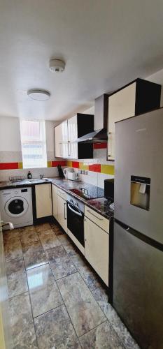 a kitchen with a refrigerator and a stove top oven at City centre lovely Apartment with the Cheapest Overnight Parking in Leicester