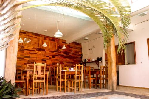Un comedor con mesas y sillas de madera. en Villa Chic Pousada, en Jericoacoara