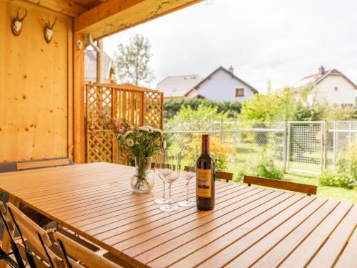 a bottle of wine sitting on a wooden table with glasses at Lungau Residence Top 0-6 in Tamsweg