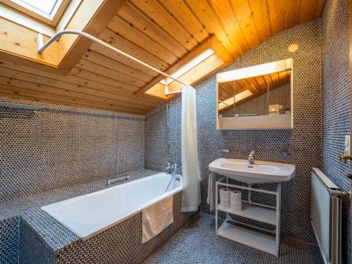 ein Badezimmer mit einer Badewanne und einem Waschbecken in der Unterkunft Chalet Alpbach 532 in Alpbach
