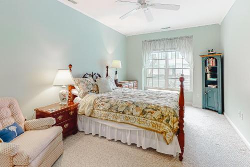 a bedroom with a bed and a chair and a window at Salt Pond -- 23 Topsail Village in Bethany Beach