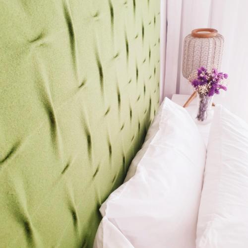 a bed with a green headboard and a white pillow at O 21 da Vila in Seia