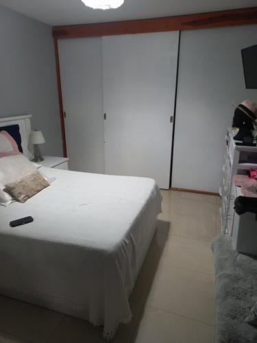 - une chambre avec un lit blanc et des portes coulissantes en verre dans l'établissement Casa MA, à San Luis Potosí