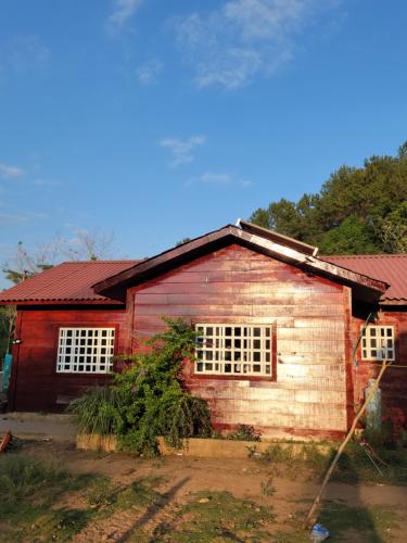 uma casa vermelha e branca com duas janelas em Quiet Cabin in San Gabriel Mixtepec 