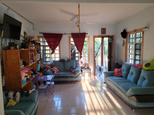 sala de estar con sofás azules y TV en Quiet Cabin in San Gabriel Mixtepec, 