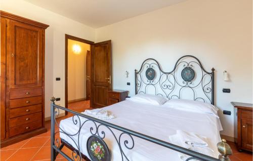 a bedroom with a white bed with a wrought iron headboard at Castello Di Tocerano in Monte Santa Maria Tiberina