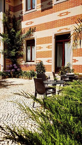 a patio with a table and chairs in front of a building at Chalet Vitorino in Sintra