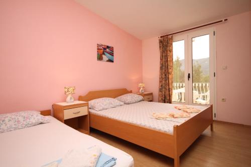 een slaapkamer met 2 bedden en een raam bij Apartments with a parking space Stari Grad, Hvar - 8757 in Stari Grad