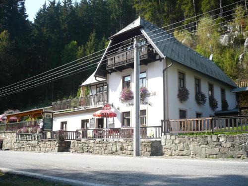 a large white building with a black roof at Pension Rybářská Bašta in Rožmberk nad Vltavou