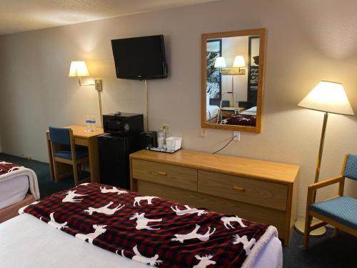 a hotel room with a bed and a mirror at Glendive Lodge in Glendive