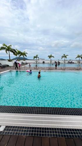 a large swimming pool with people in the water at D Naurah Meritus Guesthouse in Perai