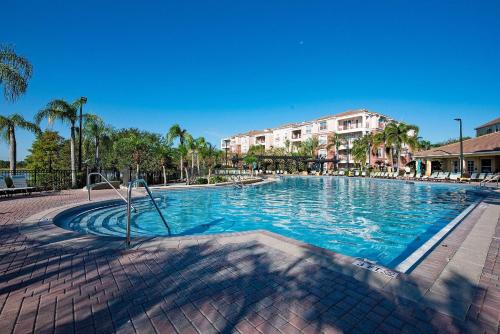 a large swimming pool in a resort with palm trees at Vista Cay Resort in Orlando