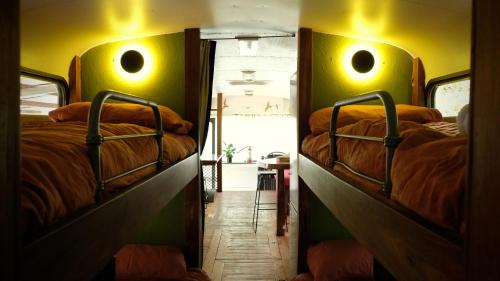 two bunk beds in a room with a mirror at Mesa Bus - Deluxe Byron Hinterland Eco Stay in Rosebank