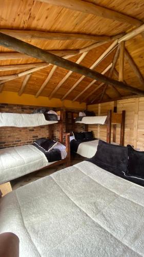 a room with three beds in a attic at Chalet Amadeus Guatavita in Guatavita