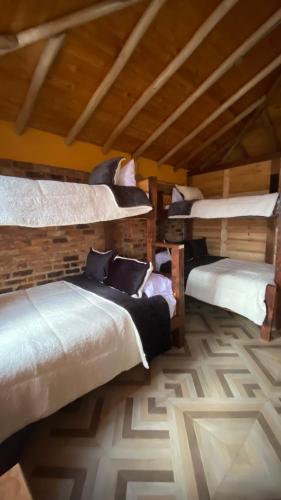 a room with three bunk beds in a building at Chalet Amadeus Guatavita in Guatavita