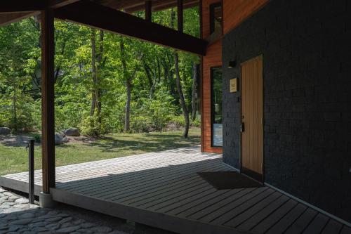 a porch of a house with a wooden door at Hygge Chalet Hakuba in Hakuba