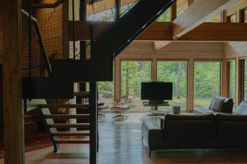 a living room with a staircase and a tv in a house at Hygge Chalet Hakuba in Hakuba