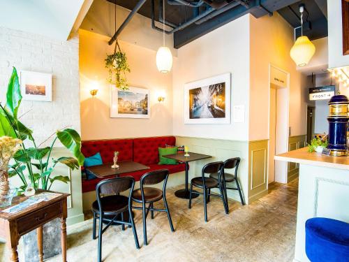 a restaurant with two tables and a red couch at Hotel Pacific Kanazawa in Kanazawa