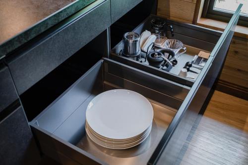 a kitchen with a stack of dishes in a drawer at Hygge Chalet Hakuba in Hakuba