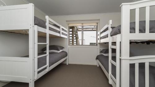 a room with three bunk beds and a window at South Coast Retreat in Inverloch