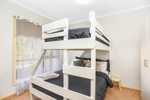 a white bunk bed in a white room with a bed at Kingsford Cottage - WIFI, Pet Friendly in Victor Harbor
