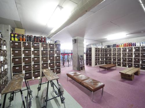 a store with racks of shoes and benches in a room at Chalet Shiga in Yamanouchi