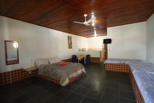 1 dormitorio con 2 camas y techo en Pousada Calvanos Chalés, en Rio das Ostras