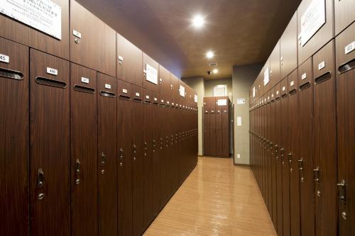 a row of wooden lockers in a locker room at Anshin Oyado Shinjuku Ekimaeten in Tokyo
