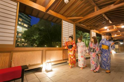 4 mujeres en kimonos parados en un porche en Arima Onsen Gekkoen Yugetsusanso, en Kobe