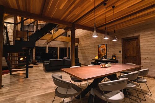 a dining room with a wooden table and chairs at Hygge Chalet Hakuba in Hakuba