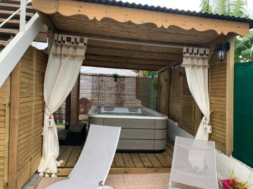 a pergola with a hot tub in a backyard at Paradise chez Nono in Baie-Mahault