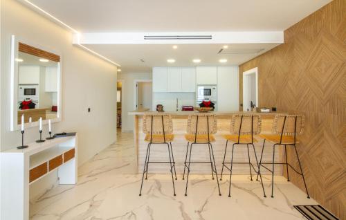 una cocina con barra y 3 taburetes en Awesome Apartment In Santa Pola With Wifi And 4 Bedrooms, en Santa Pola