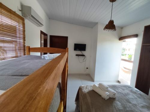 a bedroom with a bed with two towels on a table at Pousada dos Cardeais in Barra Grande