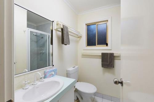 a white bathroom with a sink and a toilet at BIG4 Breeze Holiday Parks - Busselton in Busselton