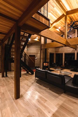 a large living room with a couch and wooden ceilings at Hygge Chalet Hakuba in Hakuba