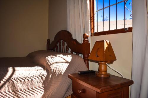 a bedroom with a bed and a table with a lamp at HOSPEDAJE LA CASONA DE CACHI in Cachí