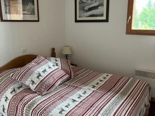 łóżko z paskowym kocem i poduszkami w obiekcie Superbe 3 Pièces avec Terrasse, Parking Privé et WIFI - 6 Couchages à Orcières - FR-1-262-178 w mieście Orcières