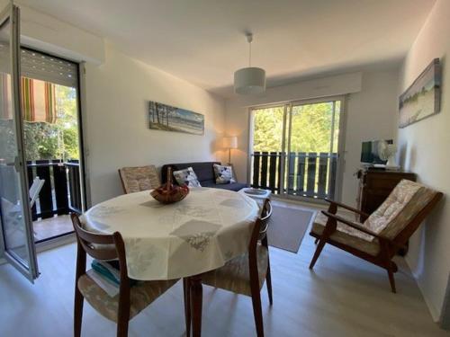 un salon avec une table, des chaises et un canapé dans l'établissement Appartement T2 rénové pour 4 pers, au pied de la plage avec 2 balcons et parking privé, St Georges - FR-1-494-135, à Saint-Georges-de-Didonne