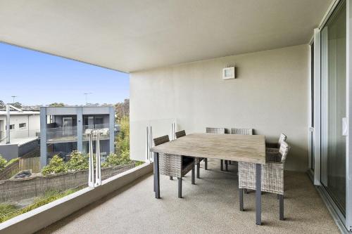 a dining room with a table and a large window at Resort Penthouse 305 in Torquay