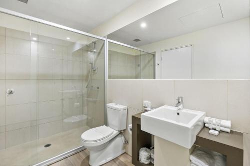 een badkamer met een toilet, een wastafel en een douche bij Resort Penthouse 305 in Torquay