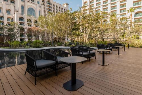 a row of chairs and tables on a wooden deck at Lotte Hotel Jeju in Seogwipo