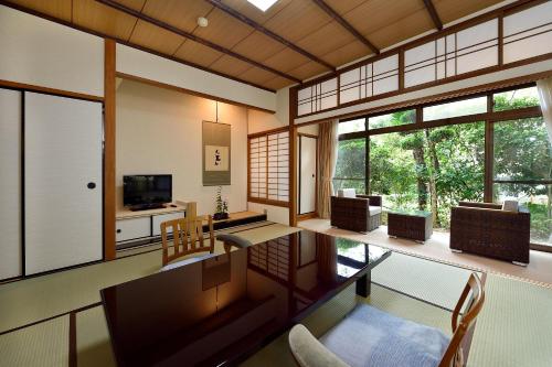 a living room filled with furniture and windows at Arima Onsen Gekkoen Yugetsusanso in Kobe