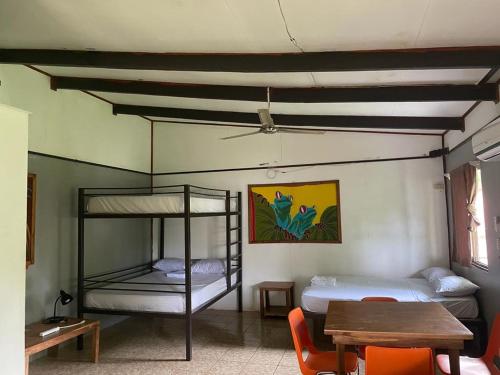 une chambre avec deux lits superposés et une table dans l'établissement Be My Guest Cabinas, à Puerto Viejo