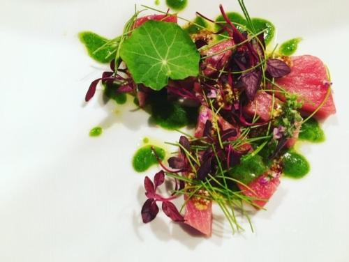 a white plate with a salad with greens and fruit at 洲本家　SUMOTOYA in Sumoto