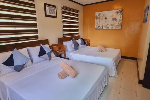 a room with two beds with white sheets at Balay sa bukid (1bedroom) in Boracay
